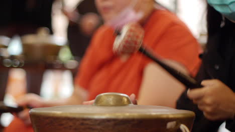 Mallet-being-used-to-hit-traditional-Indonesian-bonang-instrument,-filmed-as-close-up