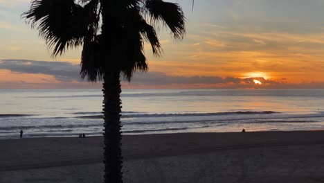 Silhouette-Einiger-Surfer-Gegen-Die-Sonne-Während-Des-Sonnenuntergangs,-Strand-Von-Carcavelos