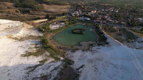 Aerial-View-of-White-Travertines,-Lake-and-Pamukkale-Town,-Turkey,-Drone-Shot