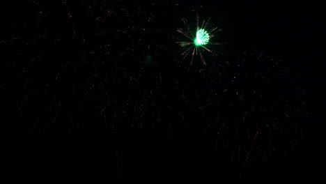 Fireworks-with-green-centers-explode-in-the-night-sky