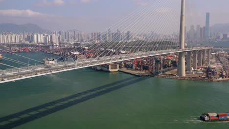 Luftdrohnenaufnahme-Der-Steinmetzbrücke-In-Hongkong-Mit-Schifffahrtshafen-Im-Hintergrund