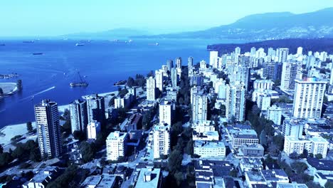 Lastkahn-Gestrandet-In-Vancouvers-Sonnenuntergang-Strand-Business-As-Usual,-Während-Schnellboote-Vorbeifahren-Und-Touristen-Die-Aussicht-Genießen-Luftpanoramaüberführung-Westseite-Der-Innenstadt-Von-Bc-Bergübersicht-Offenbart-4k-schönheit