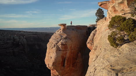 Woman-Walking-on-Top-of-the-Rock-Above-Abyss-and-Canyon-With-Breathtaking-View-on-Colorado-National-Monument-Park-USA