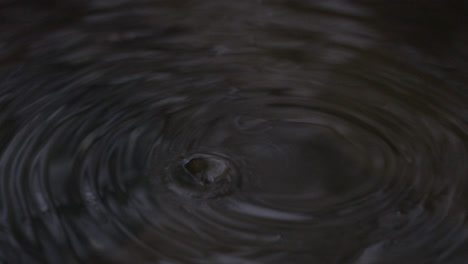 Water-droplets-fall-into-body-of-water-in-slow-motion