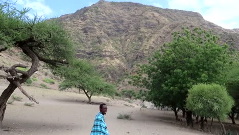 Ein-Einheimischer-Afrikanischer-Führer-In-Traditioneller-Kleidung-Posiert-Während-Einer-Klettertour-Vor-Einem-Berg