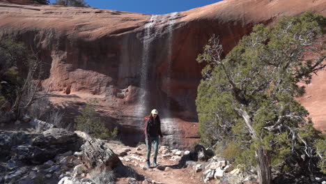 Excursionista-Femenina-Caminando-Por-Senderos-Bajo-Una-Cascada-En-El-Parque-Del-Monumento-Nacional-De-Colorado,-EE.UU.