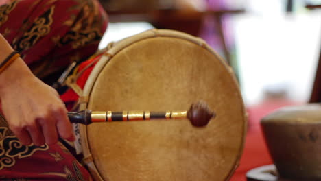 Traditional-south-east-Asian-skinned-drum-played-with-wooden-mallet,-filmed-as-close-up-in-handheld-style