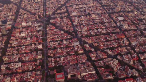 Breite-Drohnenaufnahmen-Von-Mexiko-Stadt-Bei-Sonnenuntergang-Mit-Ziegeldächern,-Geraden-Straßen-Und-Geometrischen-Mustern-Im-Urbanen-Design
