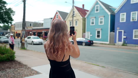 Mujer-Tomando-Fotos-De-Edificios-Coloridos-En-Su-Teléfono-Celular-En-Halifax,-Nueva-Escocia,-Canadá