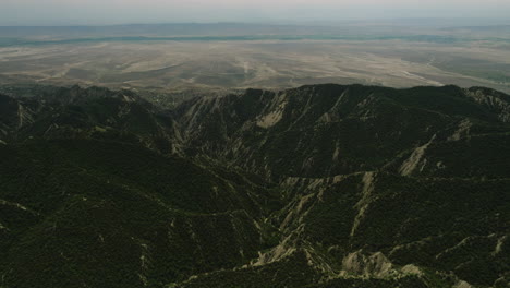 Hills-with-tree-vegetation-and-arid-steppe-beyond,-Vashlovani,-Georgia