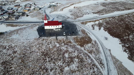 See-Iceland's-stunning-coastal-landscape-from-a-new-perspective,-with-a-drone-capturing-the-unique-architecture-of-a-Catholic-church-nestled-in-the-natural-beauty