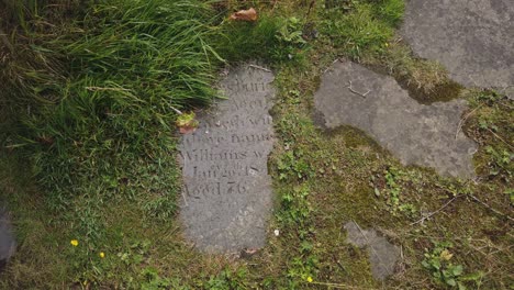 Close-up-of-a-broken-old-gravestone-merged-into-the-ground