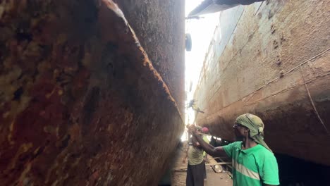 Hafenarbeiter-Hämmern-Verrostete-Schiffsrümpfe-An-Einem-Trockendock-In-Bangladesch