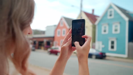 Mujer-Tomando-Fotos-De-Edificios-Coloridos-En-Su-Teléfono-Celular-En-Halifax,-Nueva-Escocia,-Canadá