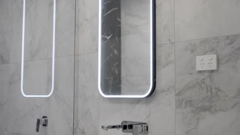Luxuriöses,-Modernes,-Zeitgenössisches-Badezimmer-Mit-LED-Spiegel,-Marmorfliesen,-Wand,-Weißes-Waschbecken,-Silberne-Wasserhähne