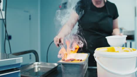 Lady-cooking-ice-cream-flambe-in-an-industrial-kitchen