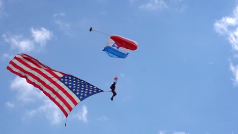 The-American-Flag-flies-in-on-a-sky-diver-as-it-lands-on-target-at-the-Wings-over-Houston-Airshow-2021