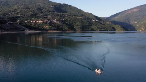 A-small-boat-crossing-a-beautiful,-calm-lake-on-a-sunny-morning-near-Debar-in-Macedonia