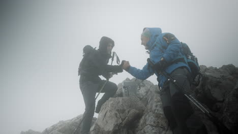 Two-hikers-reached-the-top-of-mountain-Stol,-congratulatin-each-other-with-a-hand-shake