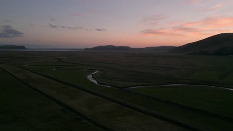 River-system-running-through-agricultural-farmland-at-sunset