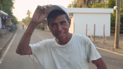 Medium-shot-of-Guatemalan-man-smiling-at-camera,-standing-in-the-street-at-sunset