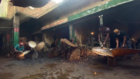 Stahlarbeiter-Polieren-Rostige-Schiffsschraube-Mit-Winkelschleifer-In-Der-Werkstattfabrik-In-Bangladesch