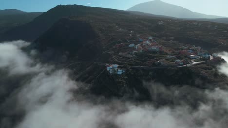 Establishing-Aerial-Shot-of-Village-on-Cloudy-Mountain-Peak,-Spain