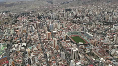 Aerial-Drone-Above-Stadium-Hernando-Siles-in-La-Paz,-Bolivia,-Populated-City-in-South-America,-High-Altitude-Neighborhood-below-Andean-Cordillera-Mountain-Rainge