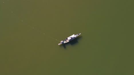 Lonely-fisherman-in-vast-river-of-Surma,-aerial-top-down-spin-view