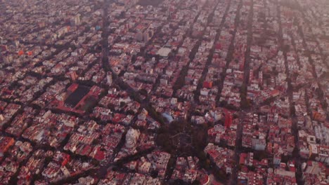 Breite-Drohnenaufnahmen-Von-Mexiko-Stadt-Bei-Sonnenuntergang-Mit-Interessanter-Straßenarchitektur-Von-Oben