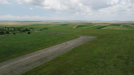 Car-driving-on-asphalt-runway-of-Big-Shiraki-military-airbase,-Georgia