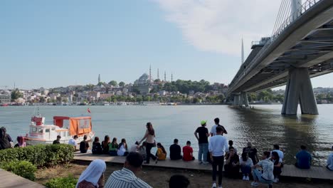 Pan-shot-of-istanbul-city,-Toursit-and-local-sitting-and-walking-under-The-Bosphorus-Bridge-known-officially-as-the-15-July-Martyrs-Bridge,-istanbul,-Tureky-on-20
