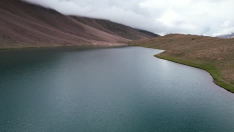 wide-aerial-dolly-left-of-Chandra-Taal-Lake-in-India-on-cloudy-day-with-no-people