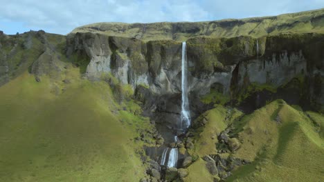 Drohnen-Push-In-Eines-Majestätischen-Wasserfalls,-Der-Auf-Felsen-Und-Die-Darunter-Liegende-Schlucht-Kaskadiert