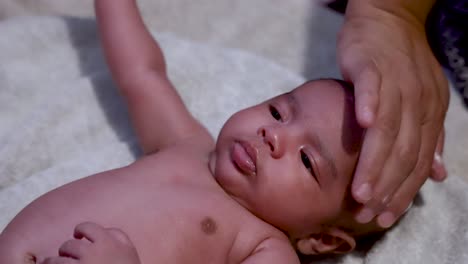 Lotion-Being-Applied-To-Adorable-2-Month-Old-Bangladeshi-Baby-After-Shower,-Laying-On-Blanket