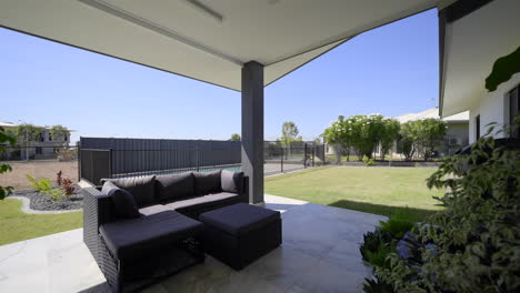 Outdoor-entertainment-area,-marble-tiles-luxurious-contemporary-outdoor-swimming-pool-in-ground,-clear-blue-water-close-up-of-pool-spa-modern-home-green-grass-blue-skies-black-fence-grey-tiled-decking