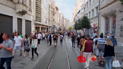 Dieses-Filmmaterial-Zeigt-Die-Lebhafte-Und-Geschäftige-Taksim-straße-In-Istanbul-An-Einem-Sonnigen-Sommertag,-An-Dem-Ansässige-Und-Touristen-Gleichermaßen-Die-Geschäfte,-Cafés-Und-Historischen-Wahrzeichen-Der-Straße-Genießen