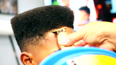 Close-up-static-shot-of-barber-doing-line-up-haircut-on-black-boy