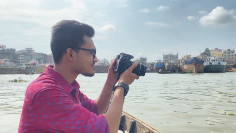 Young-male-freelance-photographer-photographing-from-boat