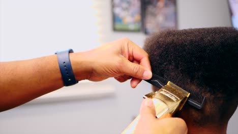 Hairstylist-hands-cutting-unrecognizable-Afro-American-kid-hair-with-electric-razor