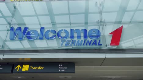 Toma-En-ángulo-Bajo-De-La-Terminal-1-De-Bienvenida-Escrita-En-El-Aeropuerto