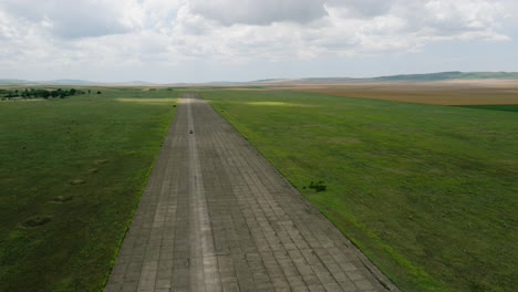 Car-driving-on-wide-paved-asphalt-runway-of-Shiraki-military-airfield