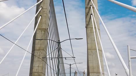 Looking-up-going-across-Tilikum-Crossing-Bridge-in-Portland-Oregon-showing-part-of-the-bridge-name-near-middle-of-clip-with-mostly-cloudy-sky-take-three