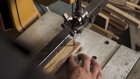 Close-shot-of-a-machine-that-is-cutting-small-piece-of-wood