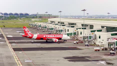 Hochwinkelaufnahme-Eines-Air-Aisa-Flugzeugs-Am-Internationalen-Flughafen-Von-Kuala-Lumpur-In-Malasiya-An-Einem-Bewölkten-Tag