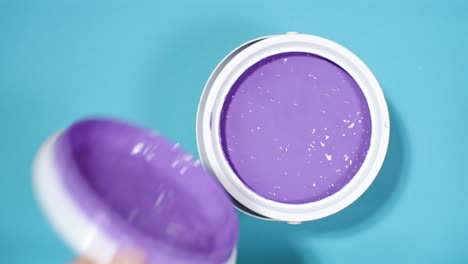 Close-shot-of-a-hand-opening-can-with-purple-paint