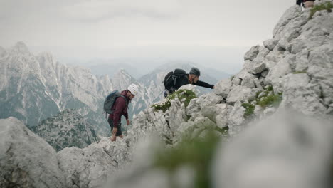 A-group-of-hikers-clombing-up-the-moutain-on-rocks-in-full-climbing-gear