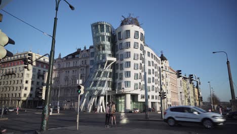 Dancing-House-or-Tancici-Dum-in-Prague,-traffic-and-people-wide-angle-view
