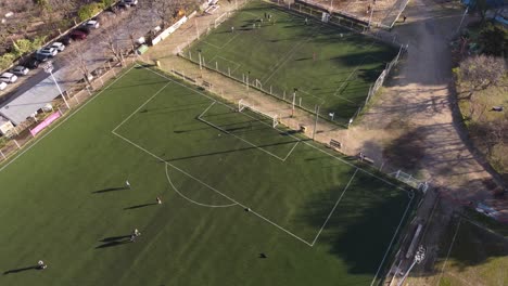 Eine-Dynamische-Luftaufnahme-Von-Fußballspielern,-Die-Auf-Zwei-Fußballfeldern-Trainieren