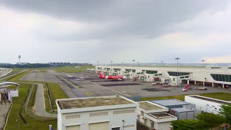 Hochwinkelaufnahme-Eines-Air-Asia-Flugzeugs-Am-Internationalen-Flughafen-Kuala-Lumpur-In-Malasiya-An-Einem-Regnerischen-Tag
